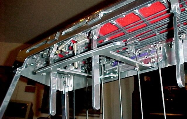 Close-up on knee levers beneath a pedal steel guitar. They look like big metal popsicle sticks.
